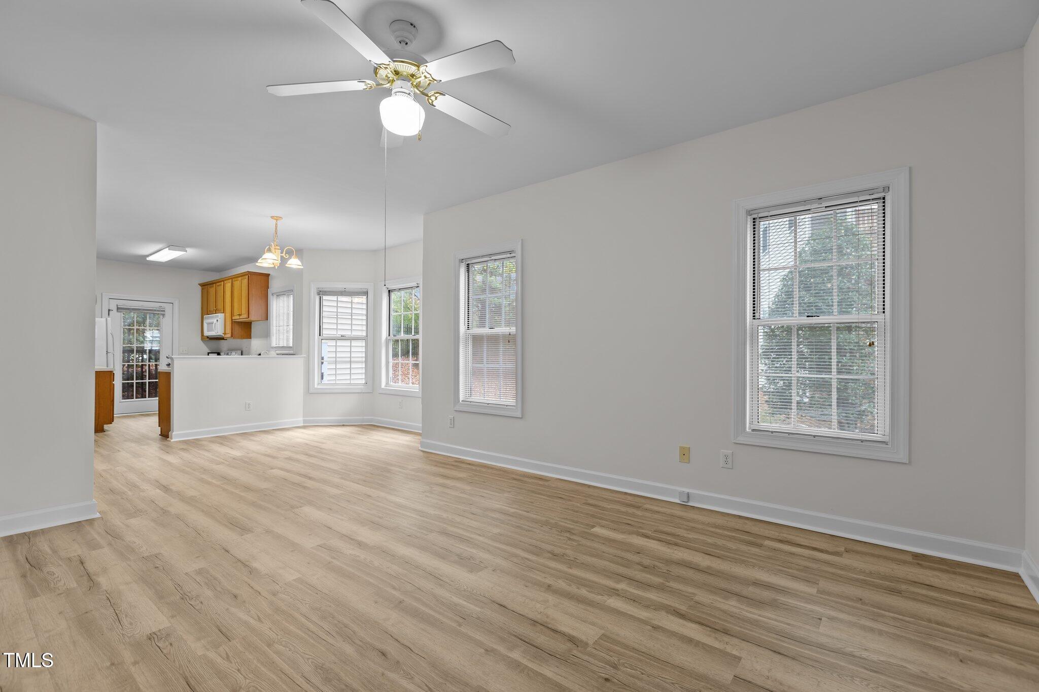 7022 Sandy Forks Road, Unit 101 Raleigh, NC 27615 - Photo 6 of 40 an empty room with wooden floor and windows