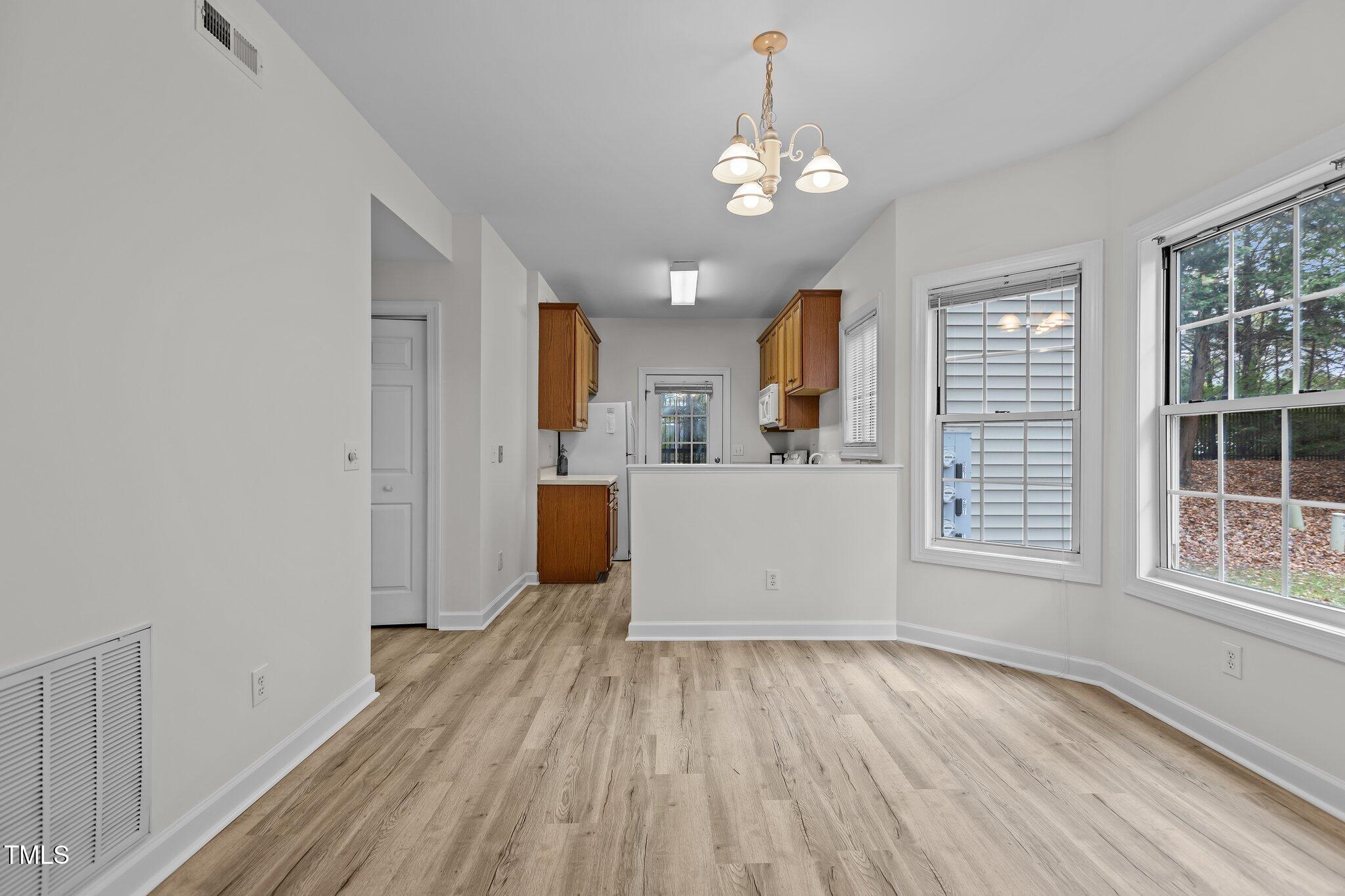 7022 Sandy Forks Road, Unit 101 Raleigh, NC 27615 - Photo 10 of 40 a view of a room with wooden floor and windows