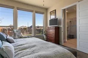 a bedroom with a bed and large windows
