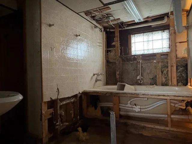 a bathroom with a sink a toilet a mirror and shower