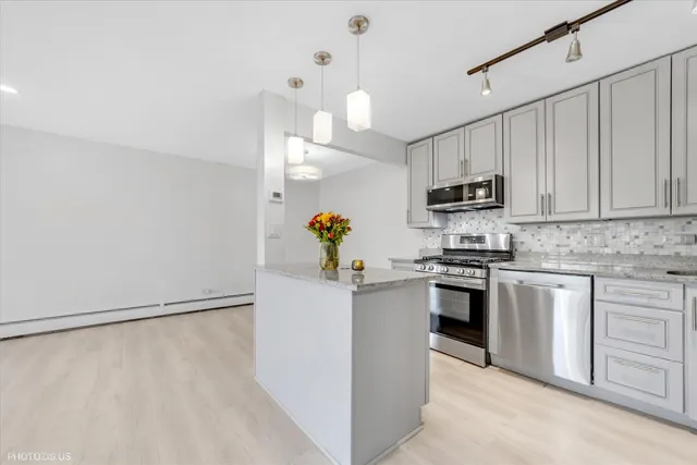 a kitchen with granite countertop cabinets stainless steel appliances and a counter space