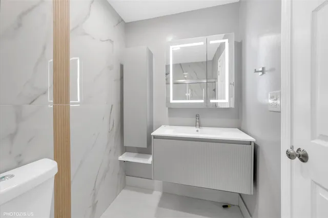 a bathroom with a sink a toilet and shower