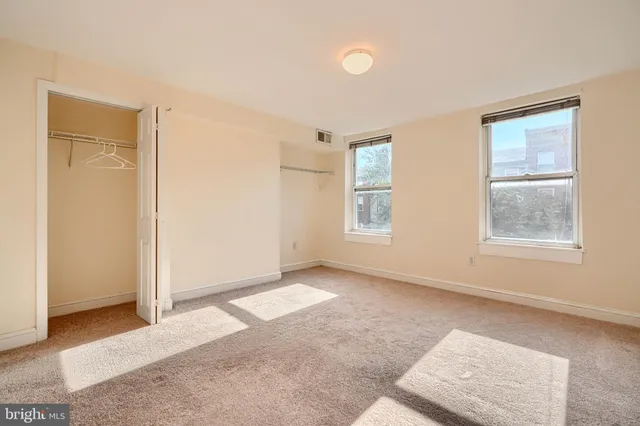 an empty room with windows and closet