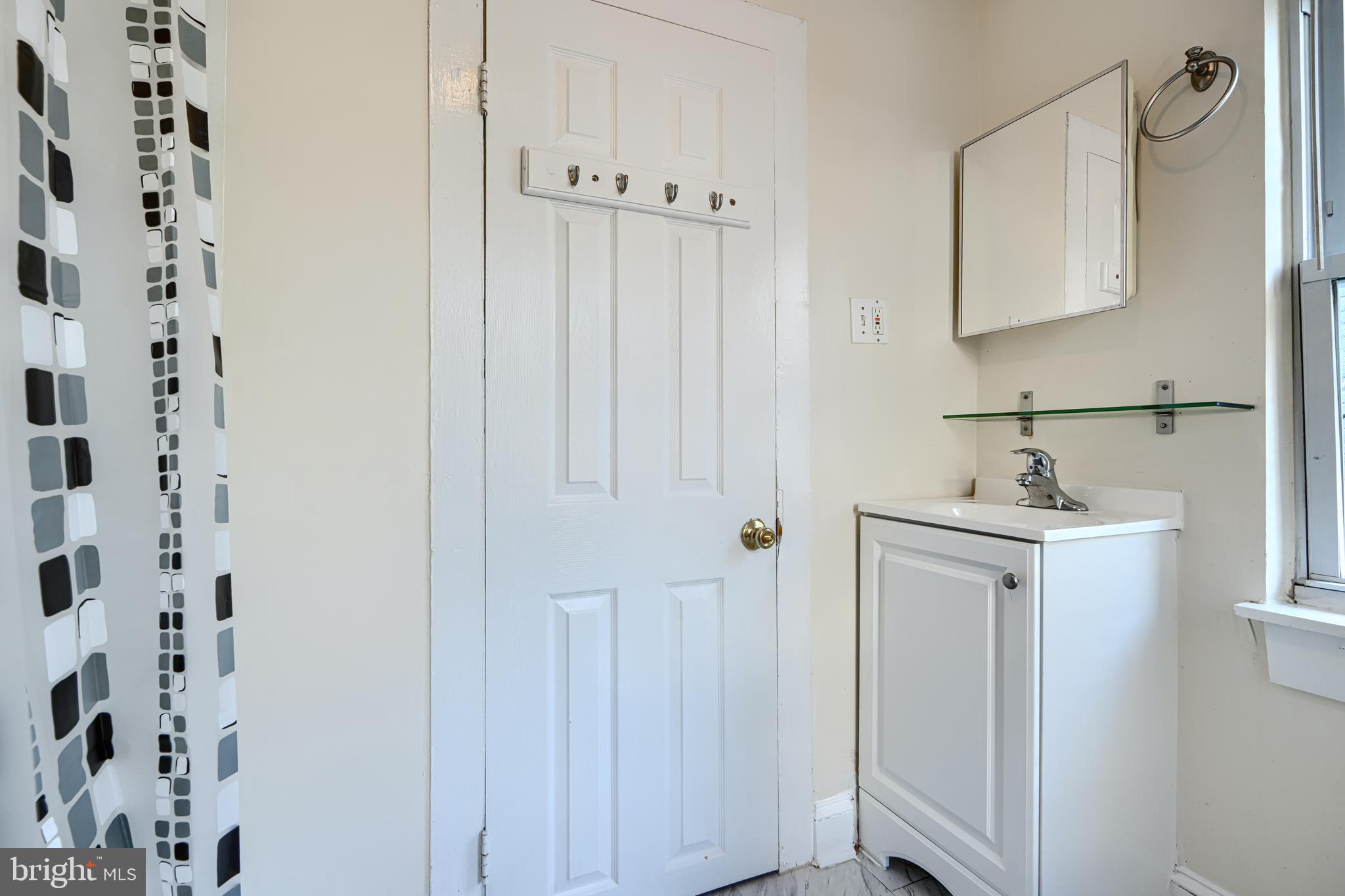 229 South Ann Street, Unit B Baltimore, MD 21231 - Photo 21 of 47 a bathroom with a sink a mirror and a shower