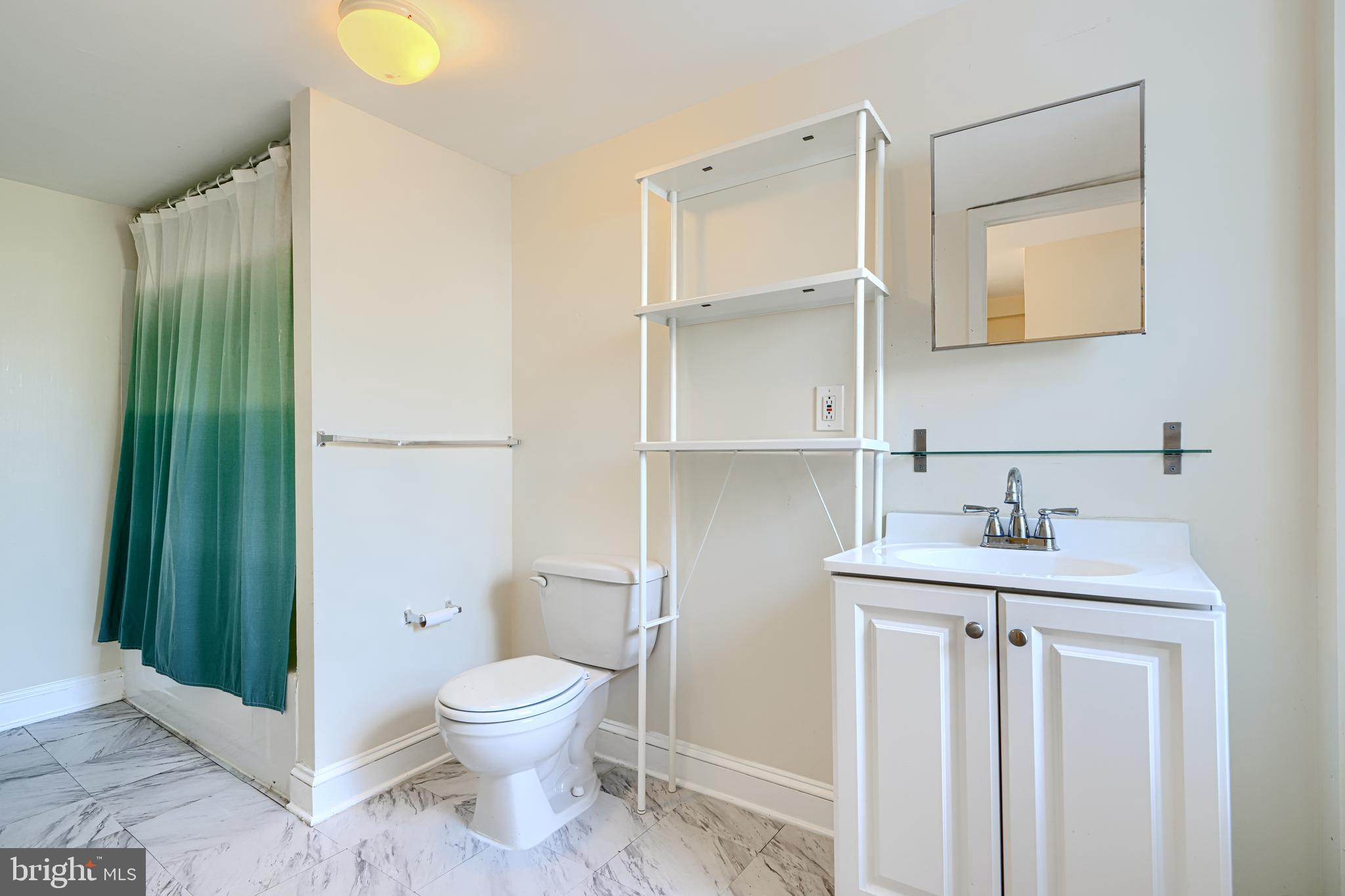229 South Ann Street, Unit B Baltimore, MD 21231 - Photo 35 of 47 a bathroom with a granite countertop sink a toilet and a mirror