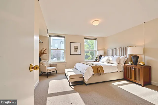 a spacious bedroom with a bed and wooden floor