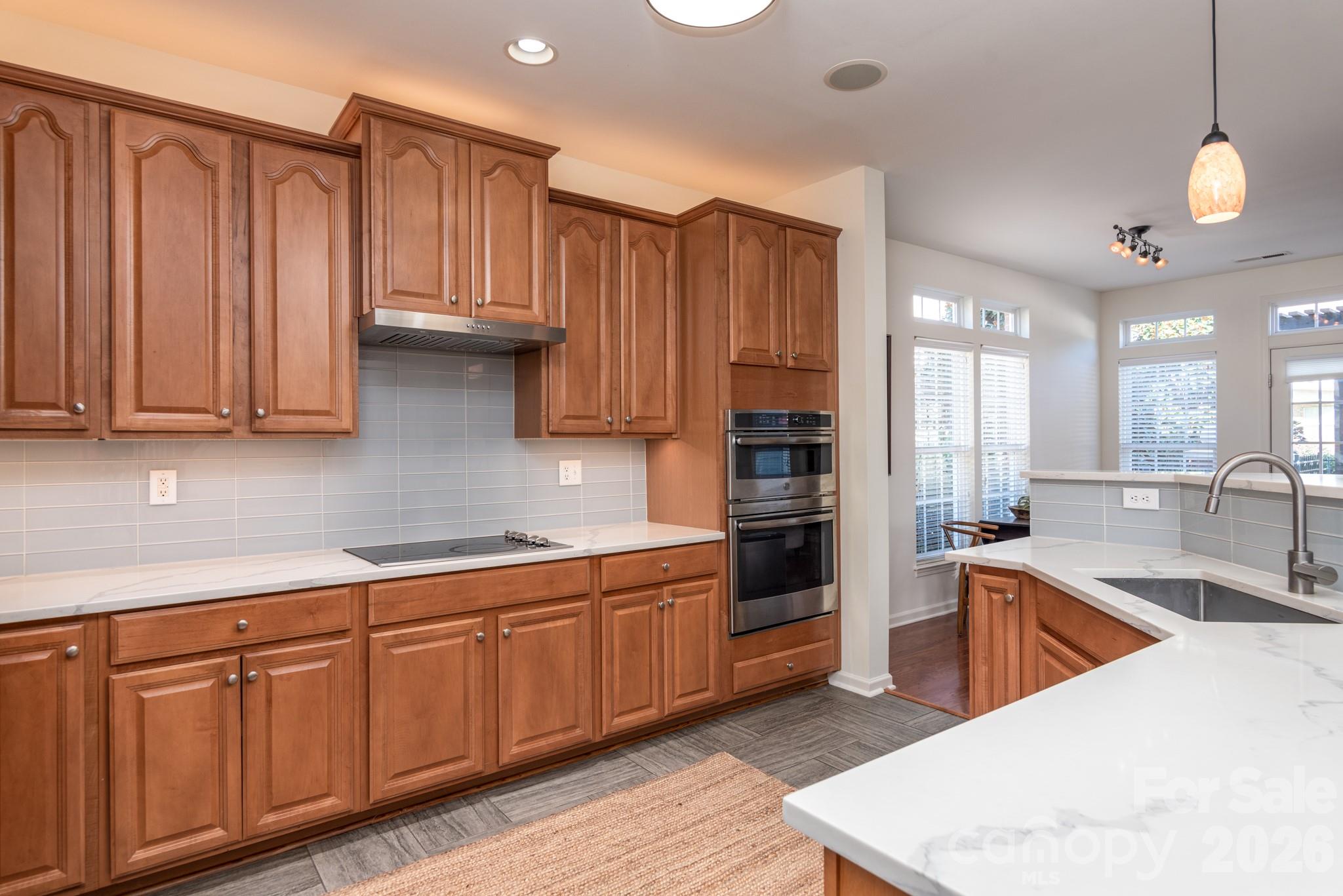 438 Magnolia Street Davidson, NC 28036 - Photo 7 of 20 a kitchen with stainless steel appliances granite countertop a sink dishwasher stove and refrigerator with wooden floor
