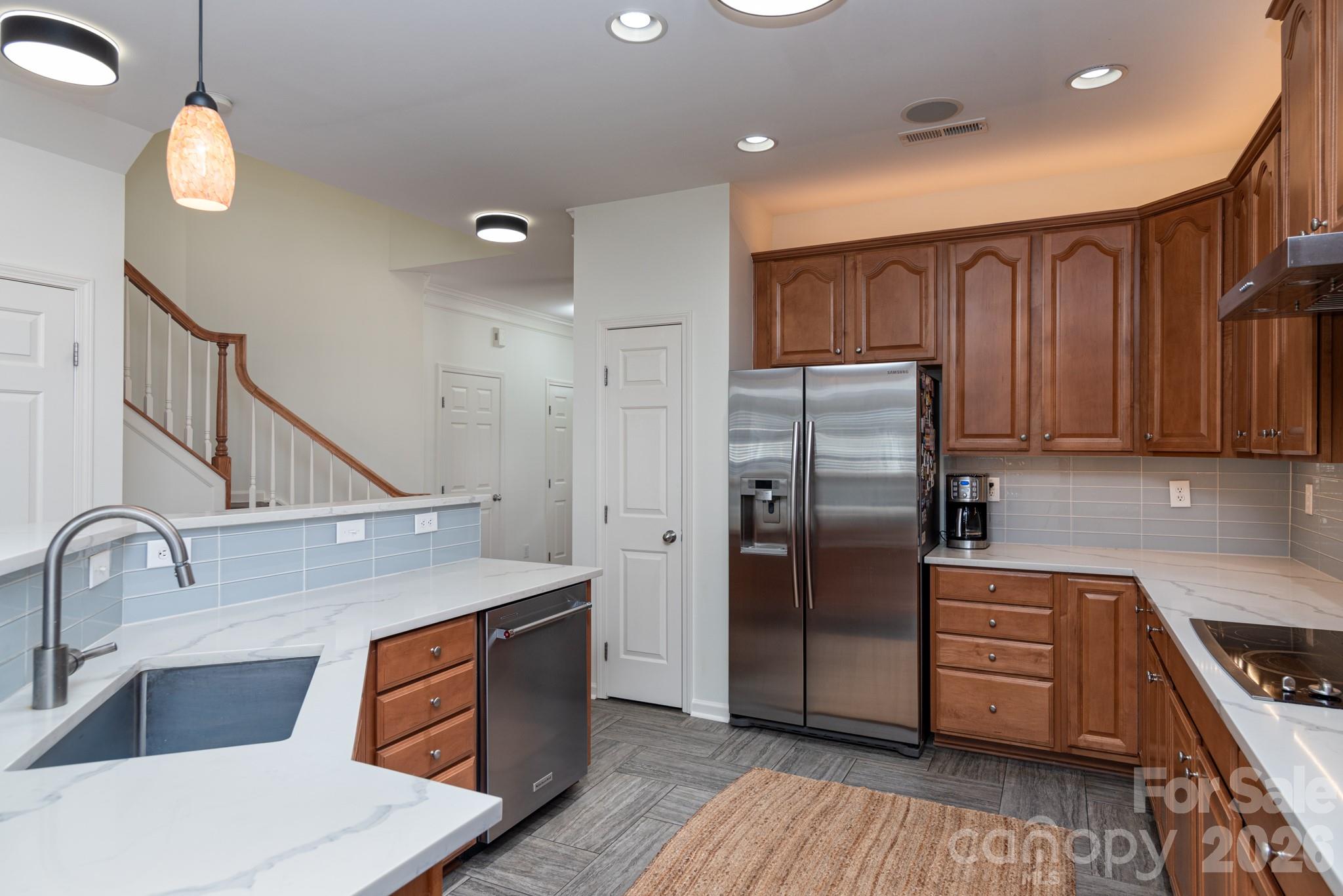 438 Magnolia Street Davidson, NC 28036 - Photo 8 of 20 a kitchen with stainless steel appliances granite countertop a refrigerator a sink dishwasher and wooden cabinets with wooden floor