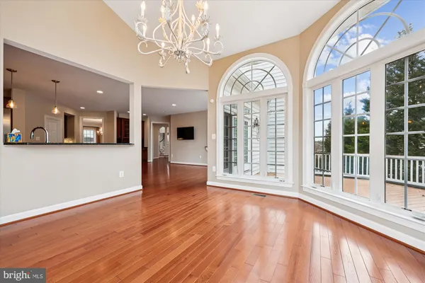 a view of a livingroom with wooden floor a fireplace and entryway
