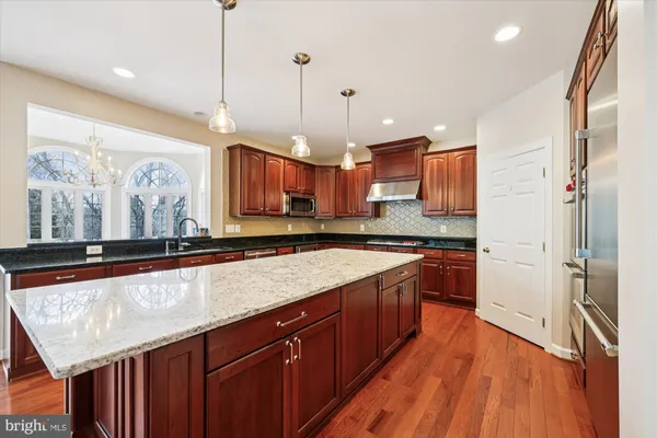a kitchen with stainless steel appliances granite countertop wooden cabinets a stove top oven a sink and dishwasher
