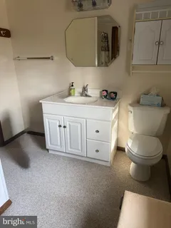 a spacious bathroom with a toilet a sink and mirror