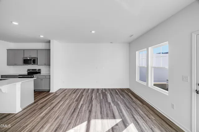 a kitchen with wooden floors and stainless steel appliances