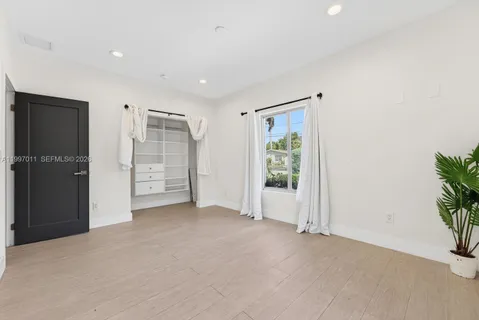 an empty room with windows and closet