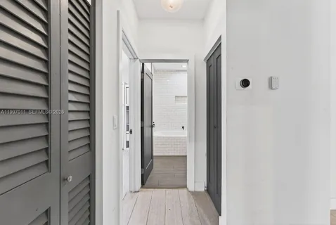 a view of a hallway with wooden floor and closet