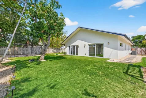 a view of house with backyard and a tree