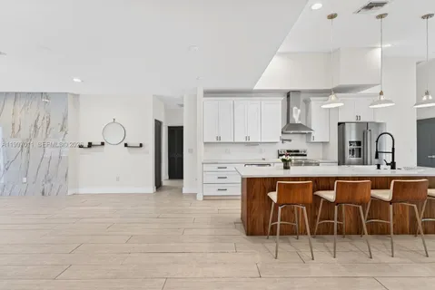 a kitchen with stainless steel appliances a sink a stove a refrigerator and cabinets
