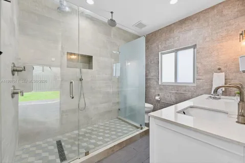 a bathroom with a granite countertop sink a shower and a mirror