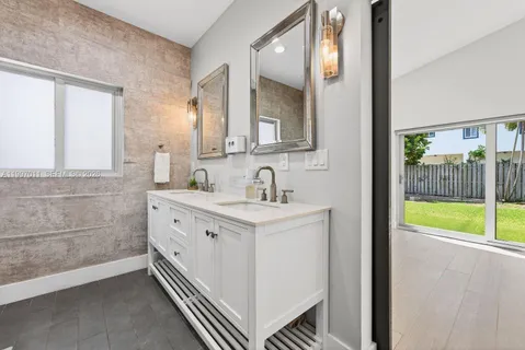 a bathroom with a sink a mirror and a bathtub