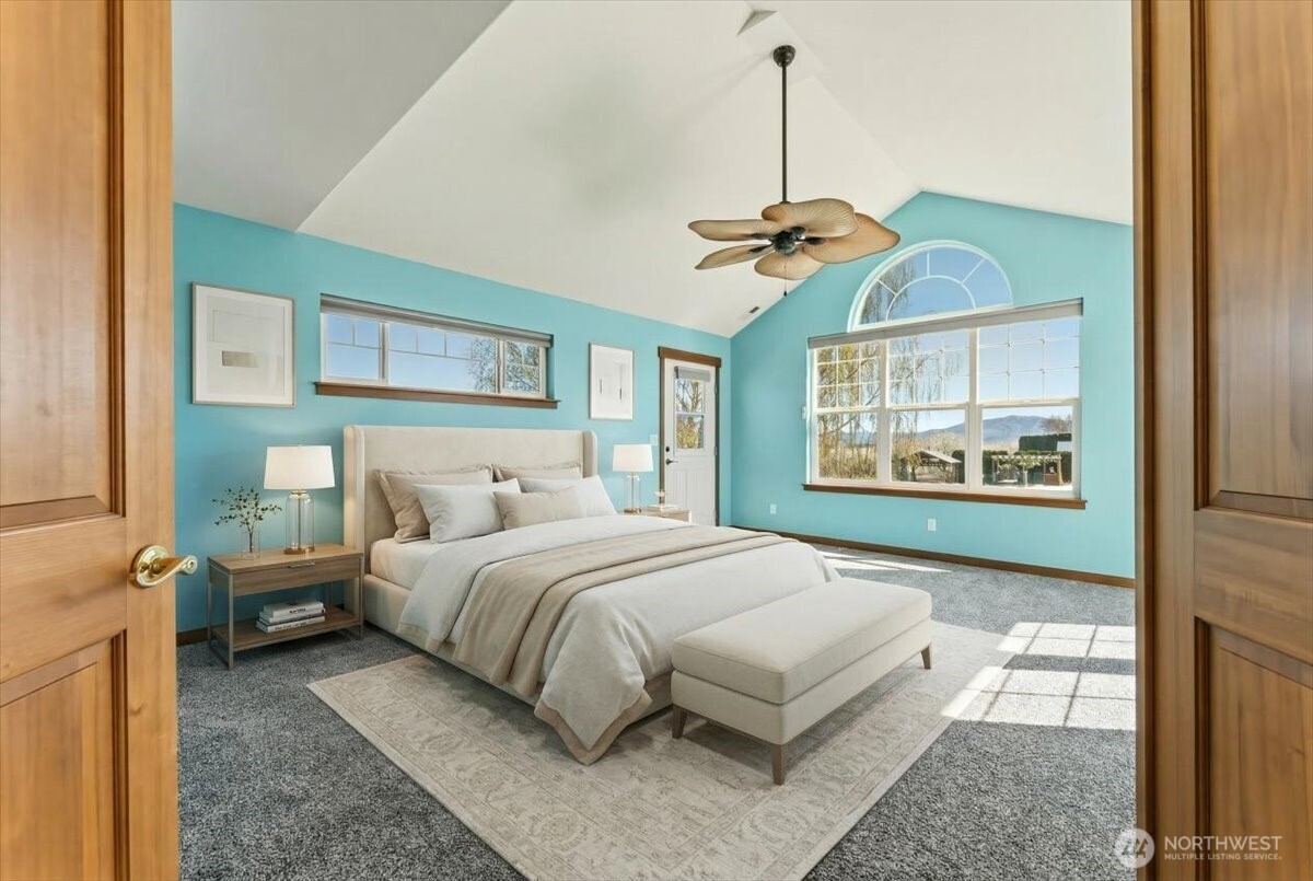 1190 Summit Boulevard Manson, WA 98831 - Photo 15 of 40 a bedroom with a large bed and a chandelier