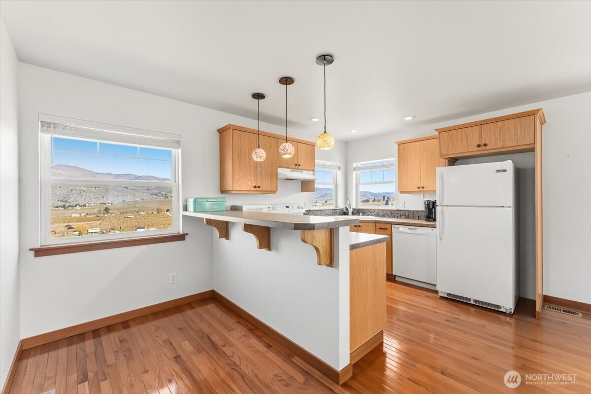 1190 Summit Boulevard Manson, WA 98831 - Photo 29 of 40 a kitchen with stainless steel appliances granite countertop a refrigerator a sink dishwasher a stove and white countertops with wooden floor