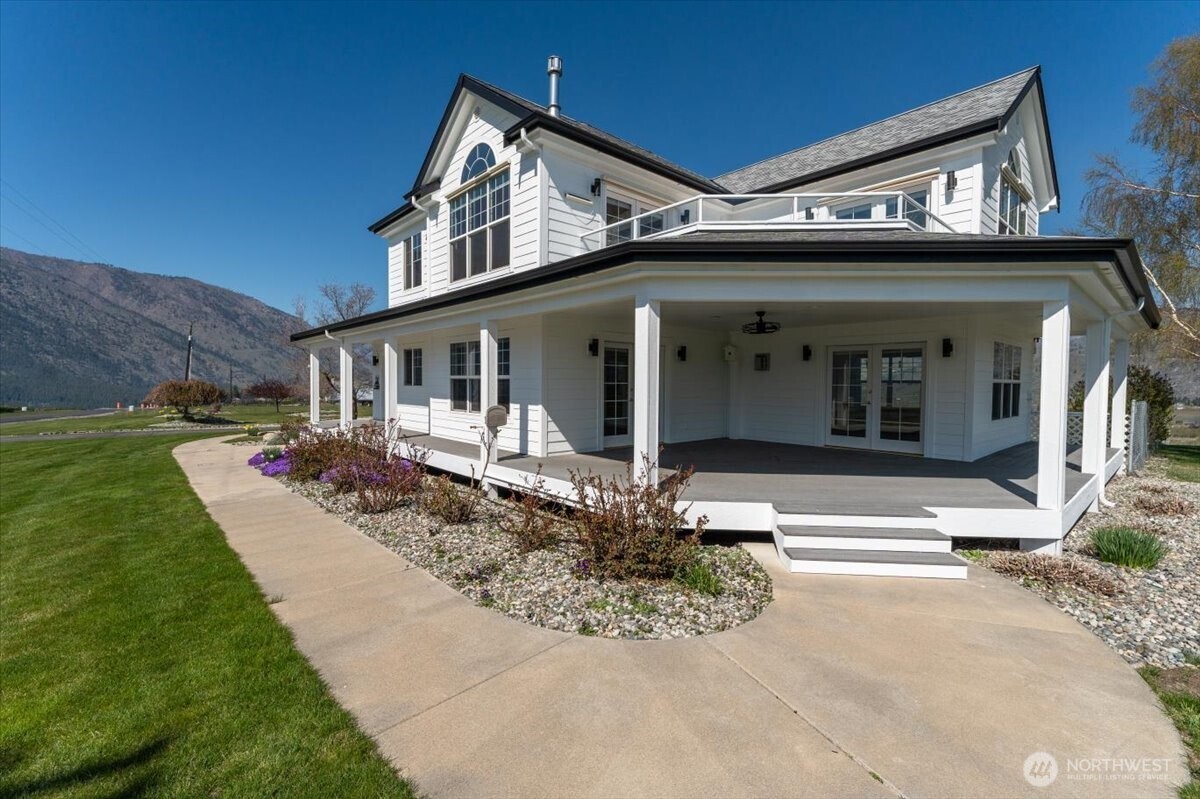 1190 Summit Boulevard Manson, WA 98831 - Photo 35 of 40 a view of a white house with a small yard plants and large tree