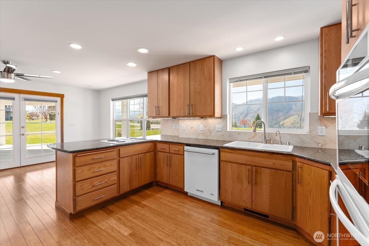 1190 Summit Boulevard Manson, WA 98831 - Photo 10 of 40 a kitchen with stainless steel appliances granite countertop wooden floors and sink