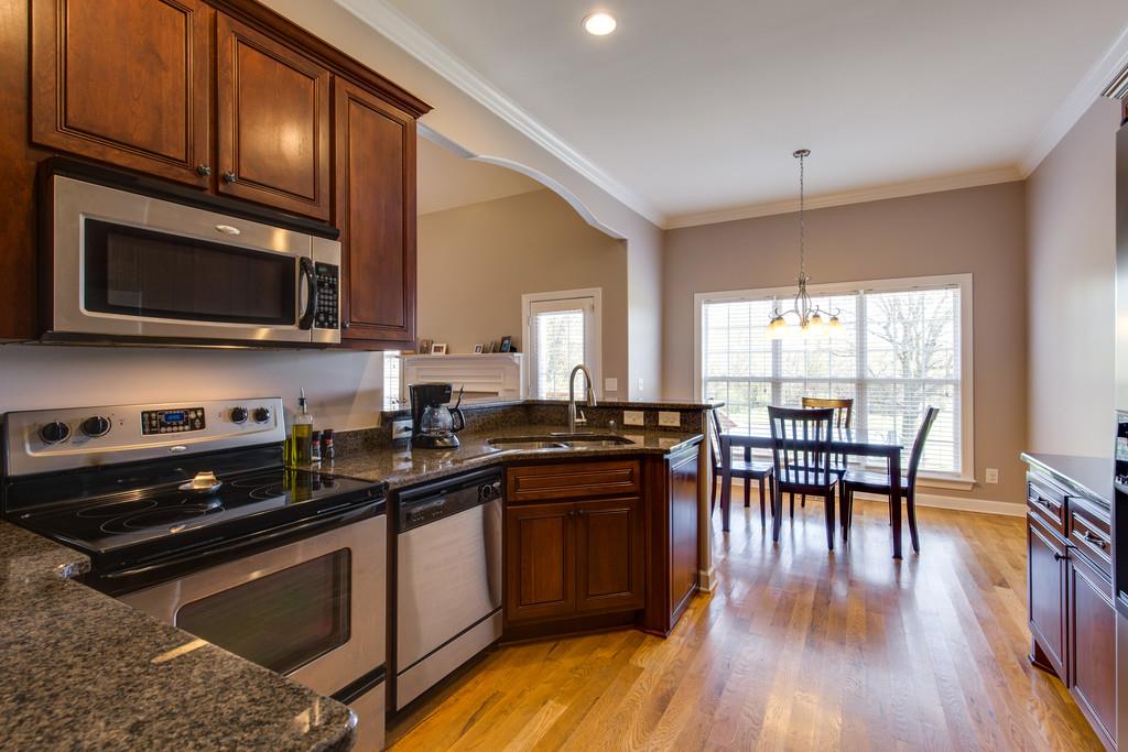501 Sugar Flat Road Lebanon, TN 37087 - Photo 9 of 16 a kitchen with granite countertop a stove top oven a sink dishwasher a dining table and chairs with wooden floor