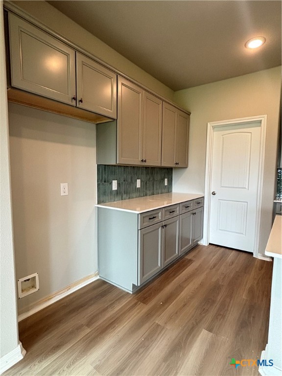 837 Swallow Drive Palacios, TX 77465 - Photo 13 of 35 a kitchen with wooden floors and white cabinets