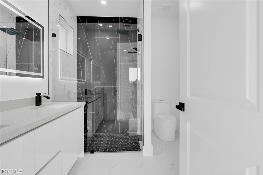 1819 Rush Avenue Lehigh Acres, FL 33972 - Photo 19 of 40 a bathroom with a sink a toilet and shower