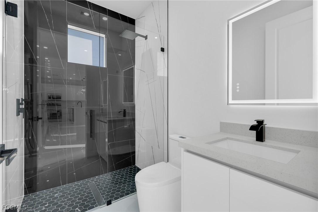 1819 Rush Avenue Lehigh Acres, FL 33972 - Photo 21 of 40 a bathroom with a sink a toilet and shower