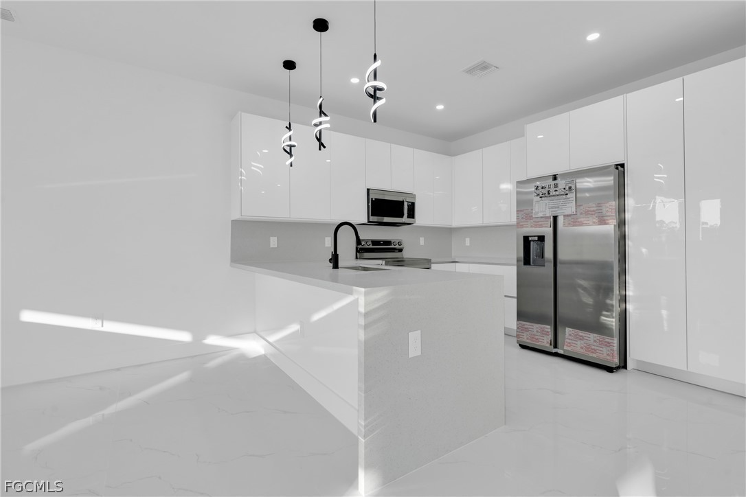 1819 Rush Avenue Lehigh Acres, FL 33972 - Photo 7 of 40 a large kitchen with cabinets and stainless steel appliances