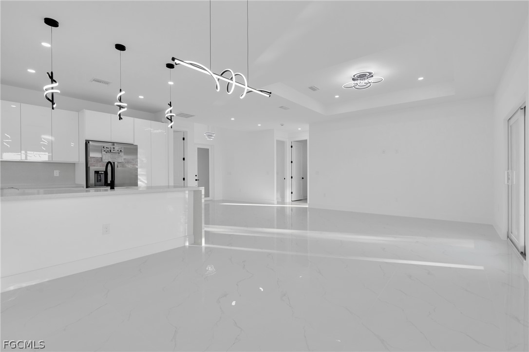 1819 Rush Avenue Lehigh Acres, FL 33972 - Photo 9 of 40 an empty room with a mirror and a ceiling fan