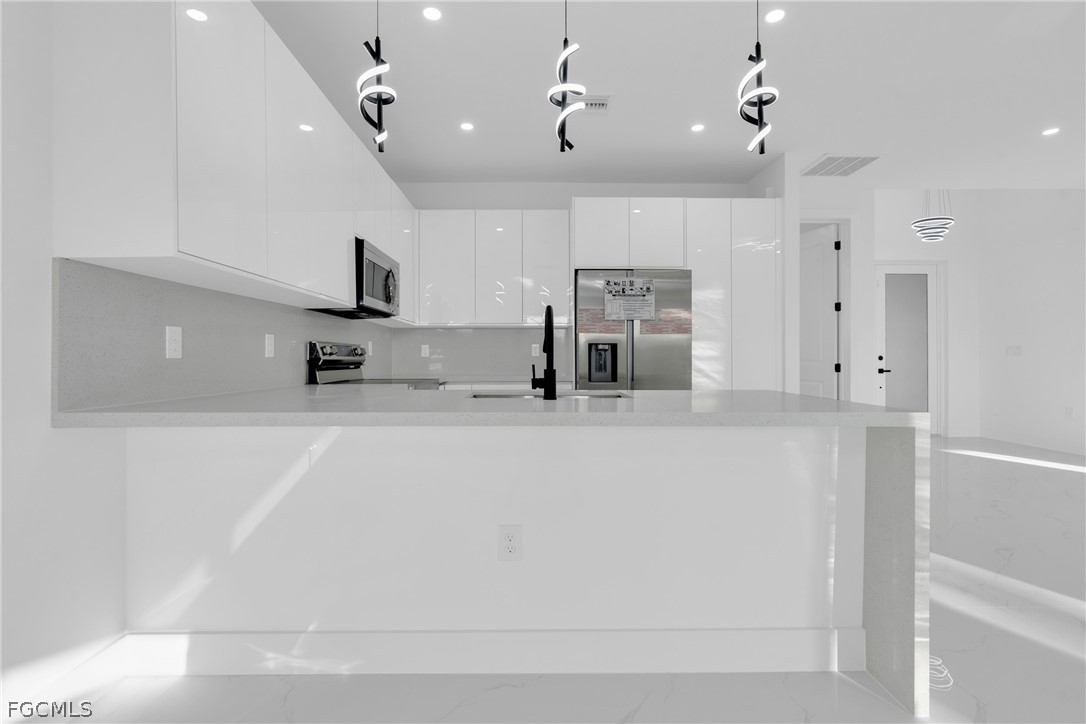 1819 Rush Avenue Lehigh Acres, FL 33972 - Photo 10 of 40 a large white kitchen with a refrigerator a sink dishwasher a stove and a refrigerator