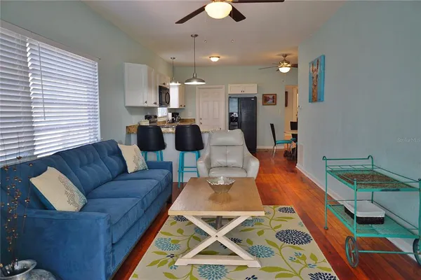 a living room with furniture and a wooden floor