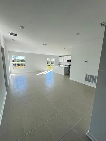 a view of empty room with wooden floor and window