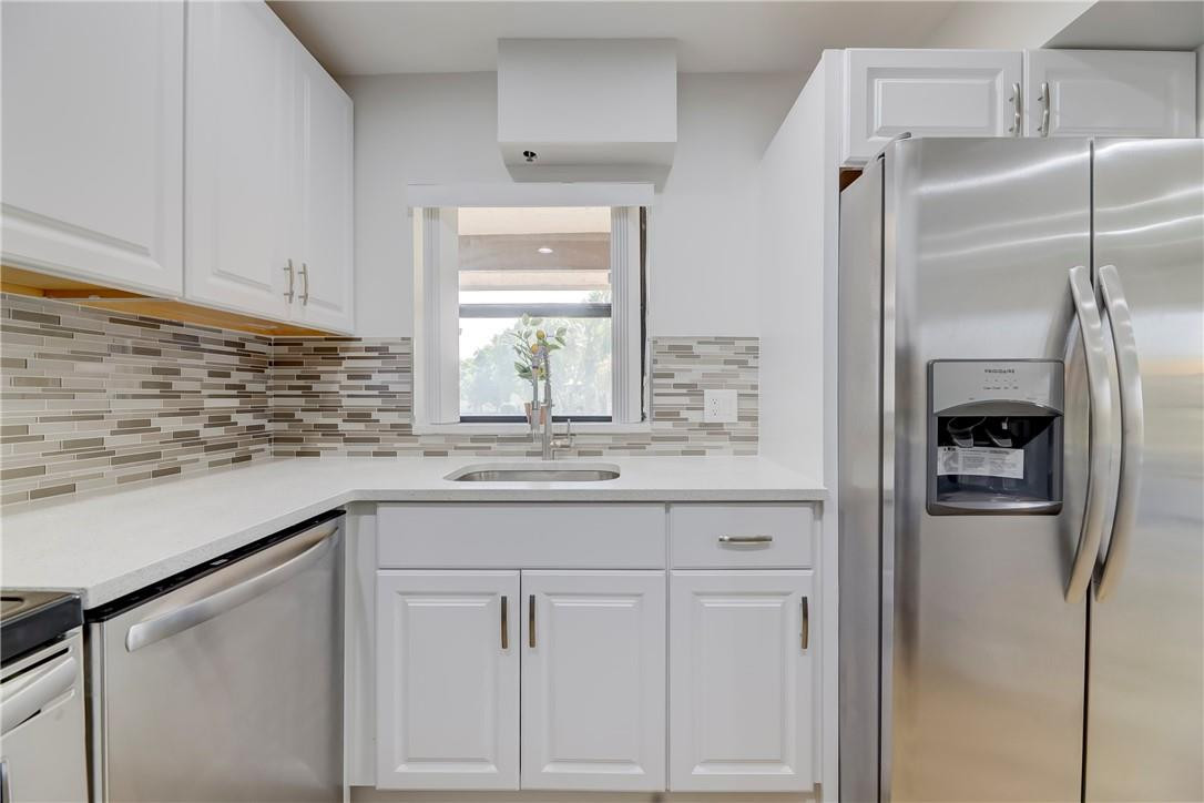 8577 Boca Glades Boulevard, Unit H Boca Raton, FL 33434 - Photo 11 of 34 a kitchen with stainless steel appliances granite countertop a refrigerator and a sink