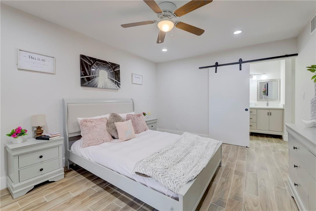 8577 Boca Glades Boulevard, Unit H Boca Raton, FL 33434 - Photo 12 of 34 a bedroom with a bed and a chandelier