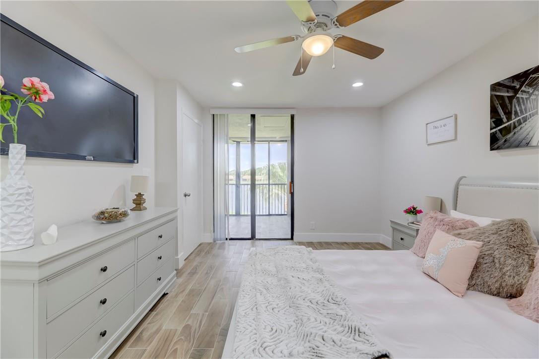 8577 Boca Glades Boulevard, Unit H Boca Raton, FL 33434 - Photo 16 of 34 a bedroom with a large bed and a flat screen tv