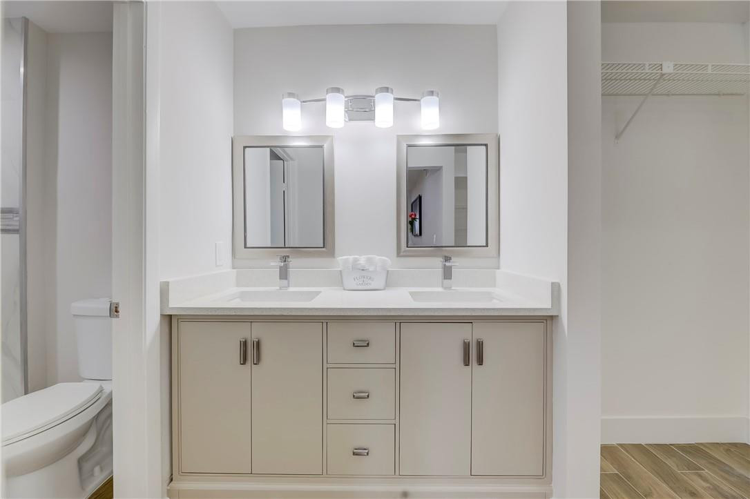 8577 Boca Glades Boulevard, Unit H Boca Raton, FL 33434 - Photo 19 of 34 a bathroom with double sink and a toilet