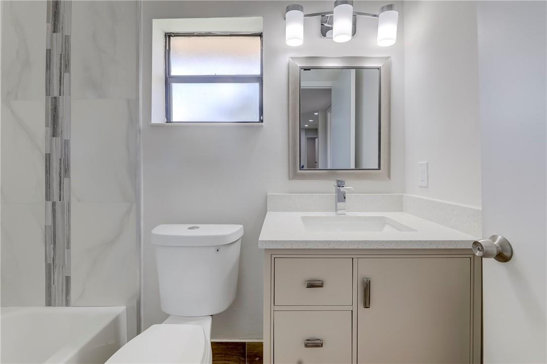 8577 Boca Glades Boulevard, Unit H Boca Raton, FL 33434 - Photo 25 of 34 a bathroom with a toilet sink and mirror