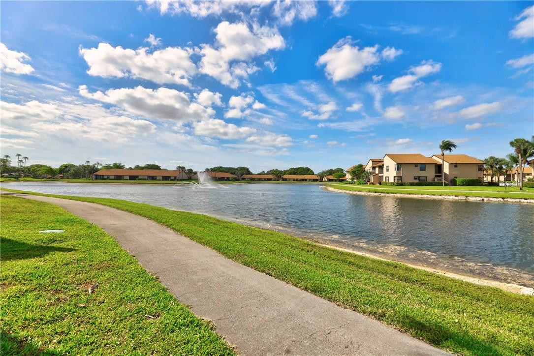 8577 Boca Glades Boulevard, Unit H Boca Raton, FL 33434 - Photo 31 of 34 a view of a lake with houses in the back