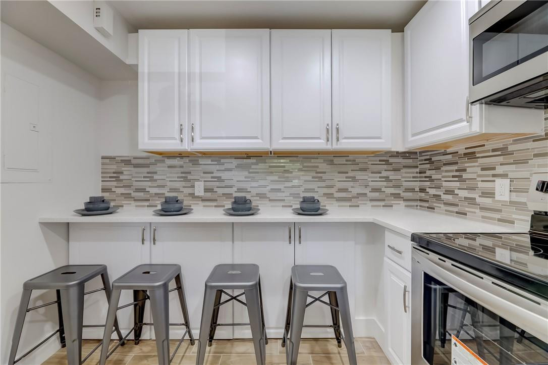 8577 Boca Glades Boulevard, Unit H Boca Raton, FL 33434 - Photo 9 of 34 a kitchen with stainless steel appliances granite countertop a stove top oven a sink and white cabinets