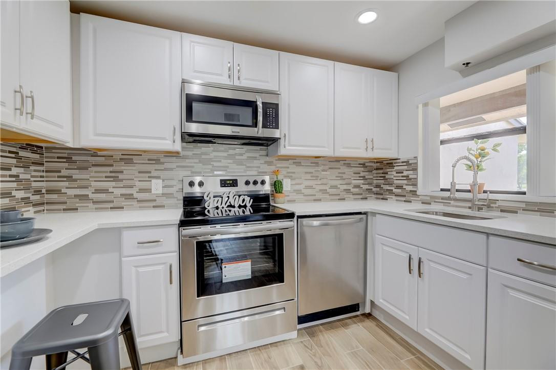 8577 Boca Glades Boulevard, Unit H Boca Raton, FL 33434 - Photo 10 of 34 a kitchen with white cabinets stainless steel appliances and sink