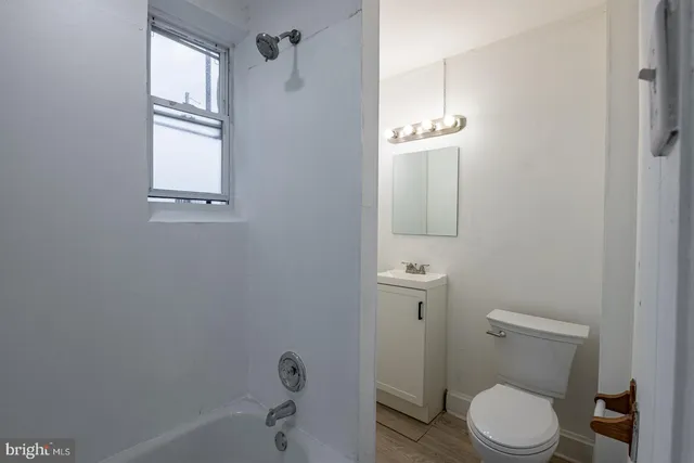 a white toilet sitting next to a bath tub
