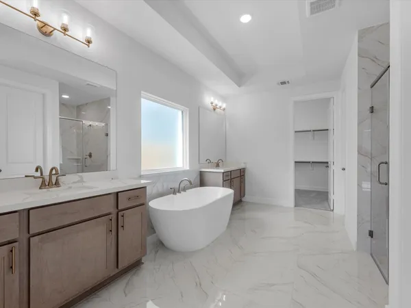 a spacious bathroom with a double vanity sink mirror and bathtub