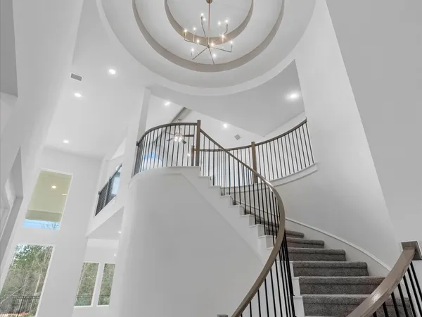 a view of staircase with railing and white walls