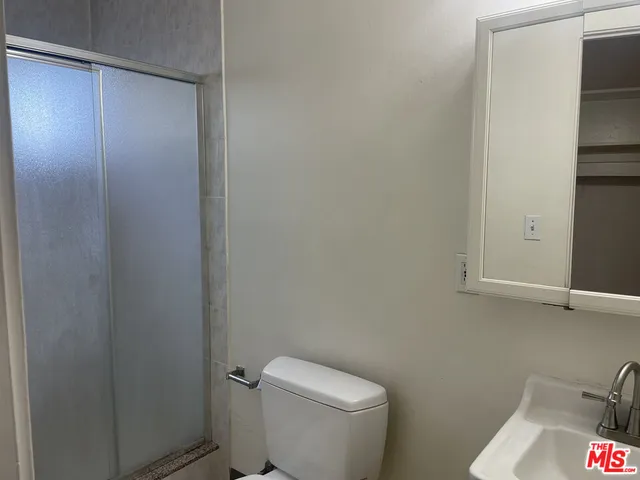 a white toilet sitting next to a shower