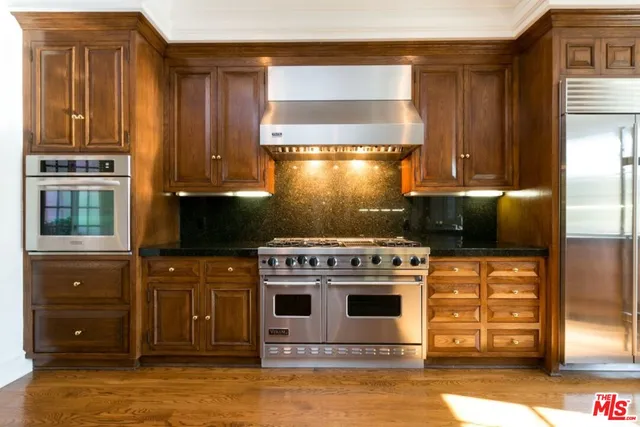 a large kitchen with stainless steel appliances granite countertop a stove and a sink