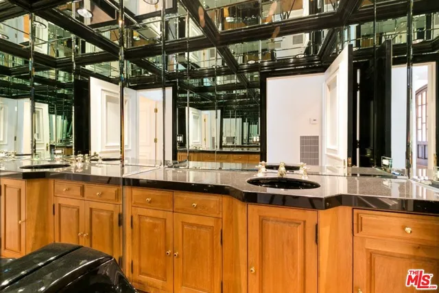 an empty room with wooden floor and a kitchen