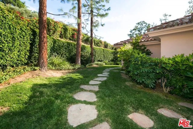 a front view of a house with a garden and plants